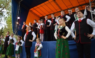 Zdjęcie grupowe uczestników wydarzenia podczas występu na scenie.