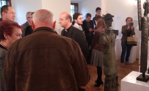 Zdjęcie przedstawia uczestników wystawy. Po prawej stronie znajduje się rzeźba.