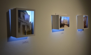 Zdjęcie przedstawia elementy wystawy - trójwymiarowe modele zdjęć, umieszczone w podświetlanych, szerokich pudełkach.