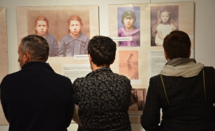 Zdjęcie przedstawia trzech uczestników wystawy stojących na tle ekspozycji.