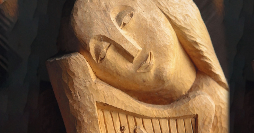 drewniana rzeźba ludowa przedstawiająca kobietę z harfą