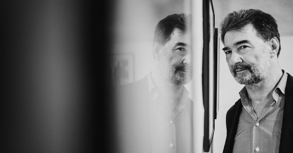 czarno-biała fotografia przedstawia portret mężczyzny i jego lustrzane odbicie